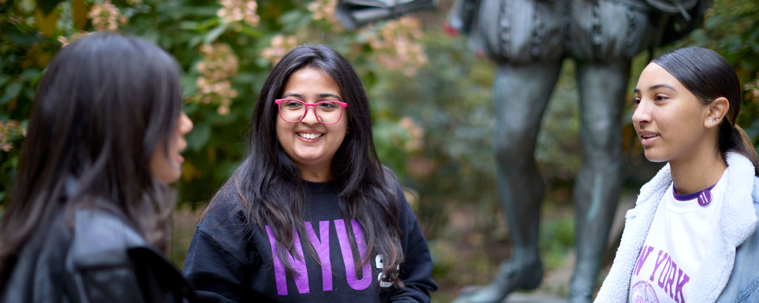 Three NYU SPS prospective students chat in a park before an admissions event