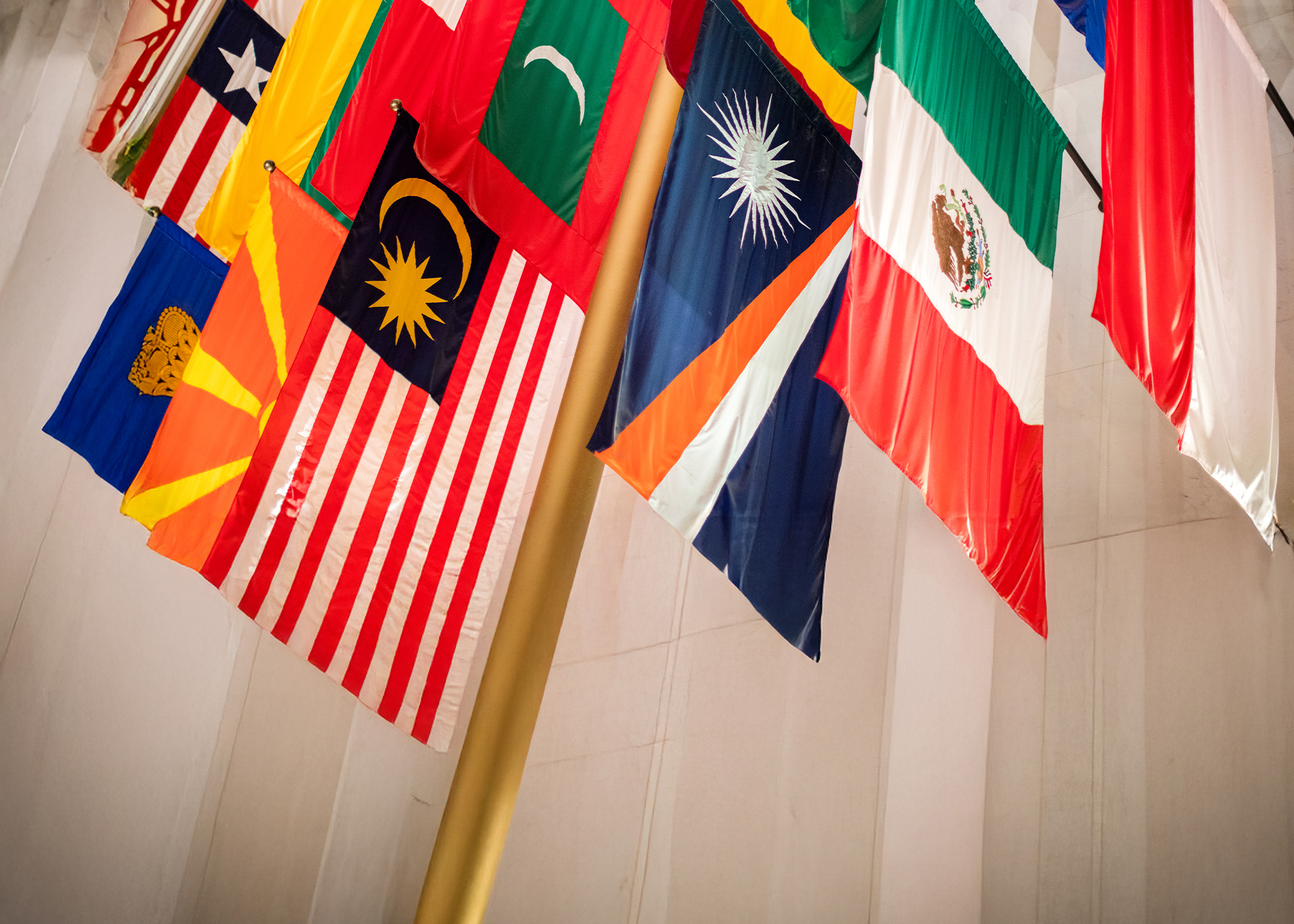 A row of international flags hanging from the ceiling at NYU's Center for Global Affairs
