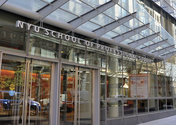 An exterior shot of an entrance to NYU SPS, composed of many floor-to-ceiling windows as well as glass revolving dorors.