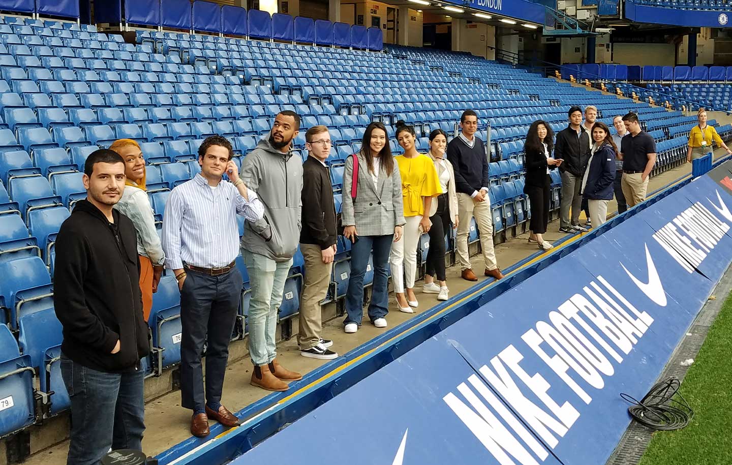 NYU SPS students standing together in the bleachers of a sports stadium.